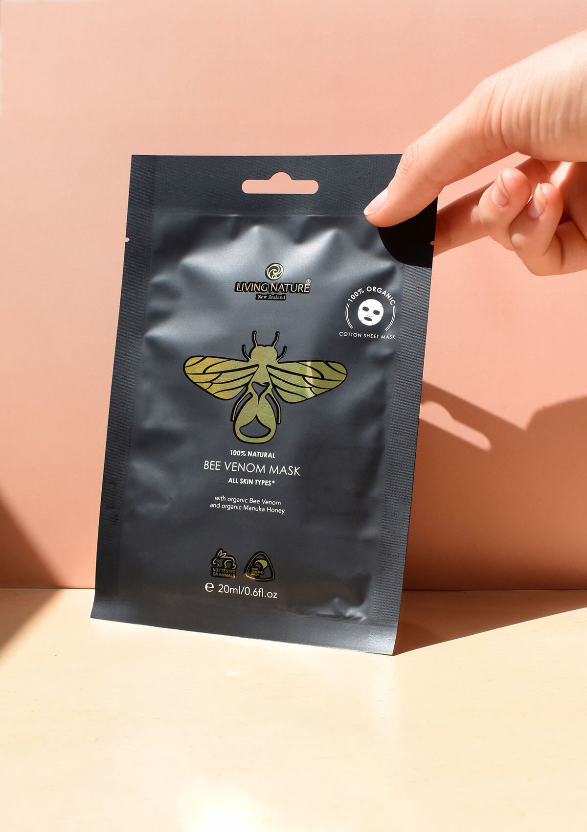 eine Hand hält die schwarze Verpackung der Bee Venom Mask