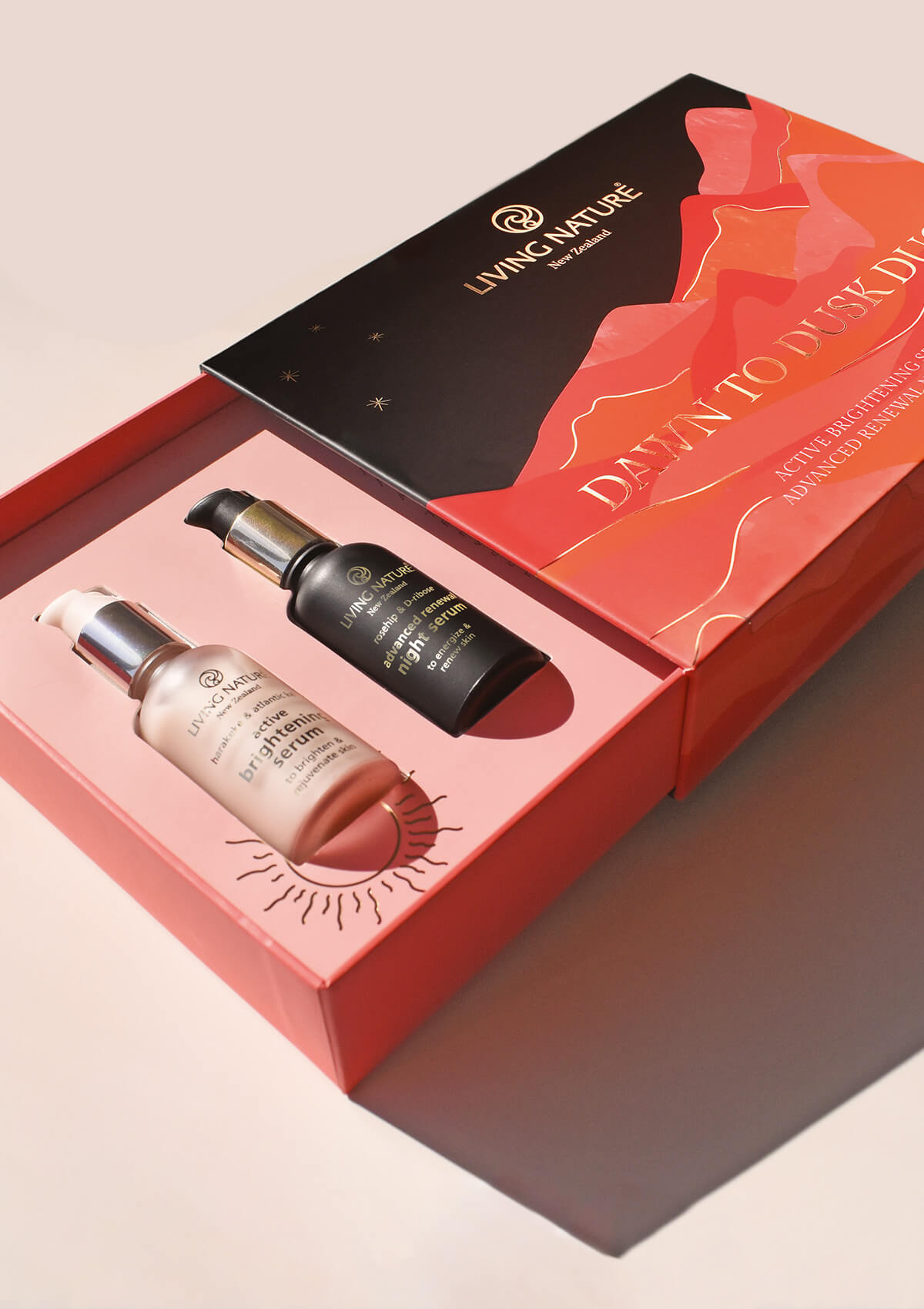 Active Brightening Serum und Advanced Renewal Night serum liegend in einer geöffneten Geschenkverpackung in rot und schwarz mit goldener Schrift