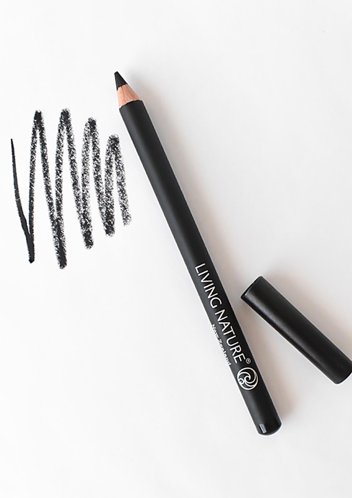 Augenkonturenstift in schwarz mit danebenliegendem Deckel. Daneben sind ein paar Striche in schwarz aufgezeichnet