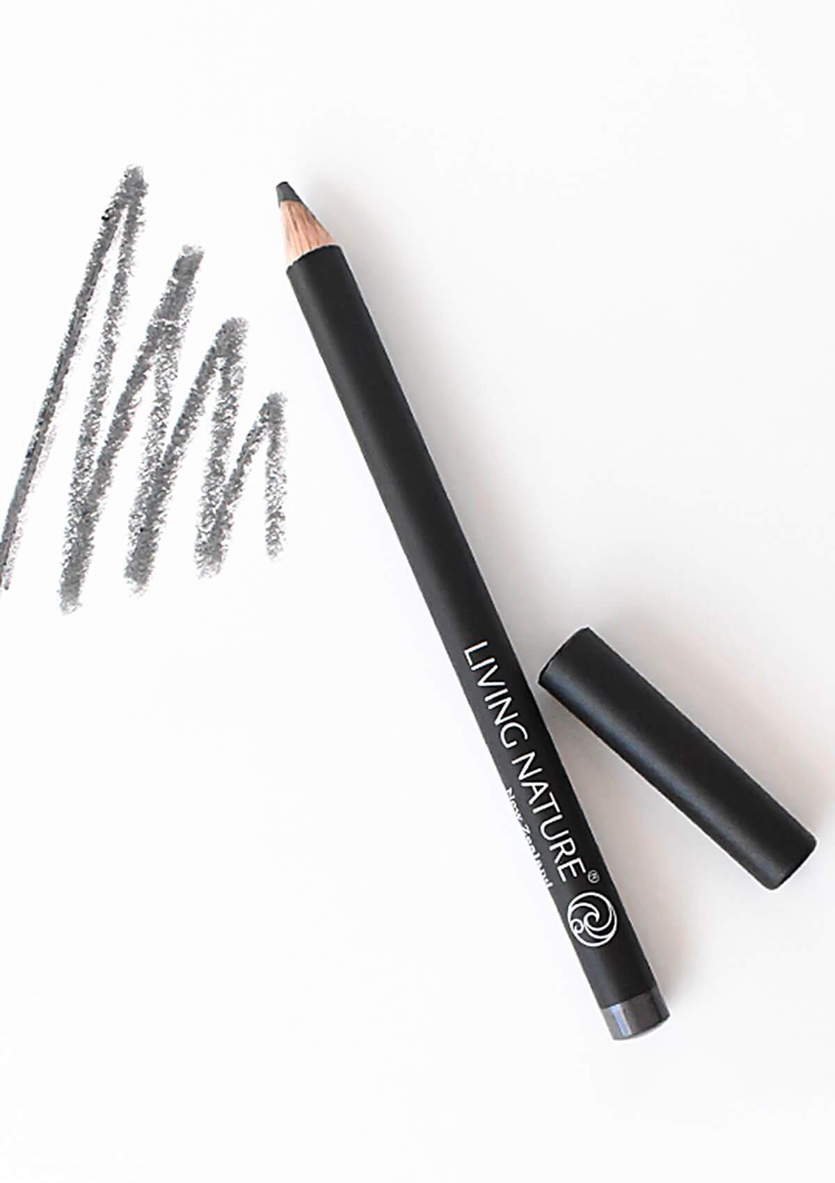 Augenkonturenstift in grau mit danebenliegendem Deckel. Daneben sind ein paar Striche in grau aufgezeichnet